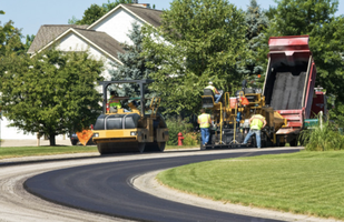 Asphalt paving contractors working on repaving a driveway in Lancaster PA